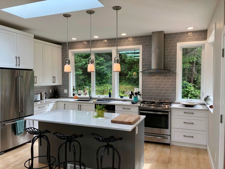 Kitchen and island, counters, stove, windows to outside